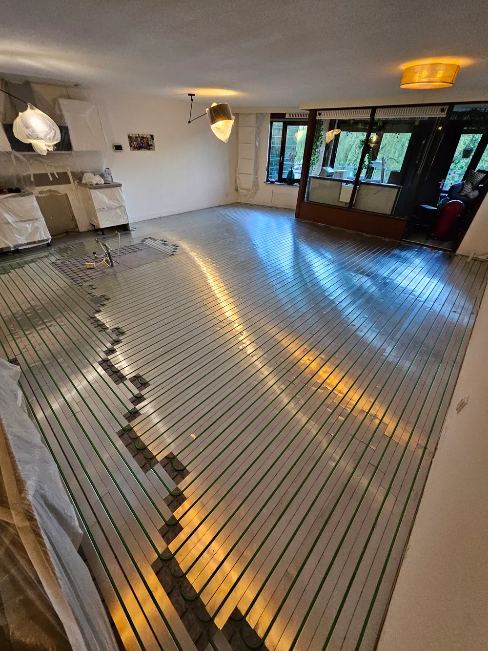 Afgewerkte vloerverwarming in ruime woonkamer met doorkijk naar tuin