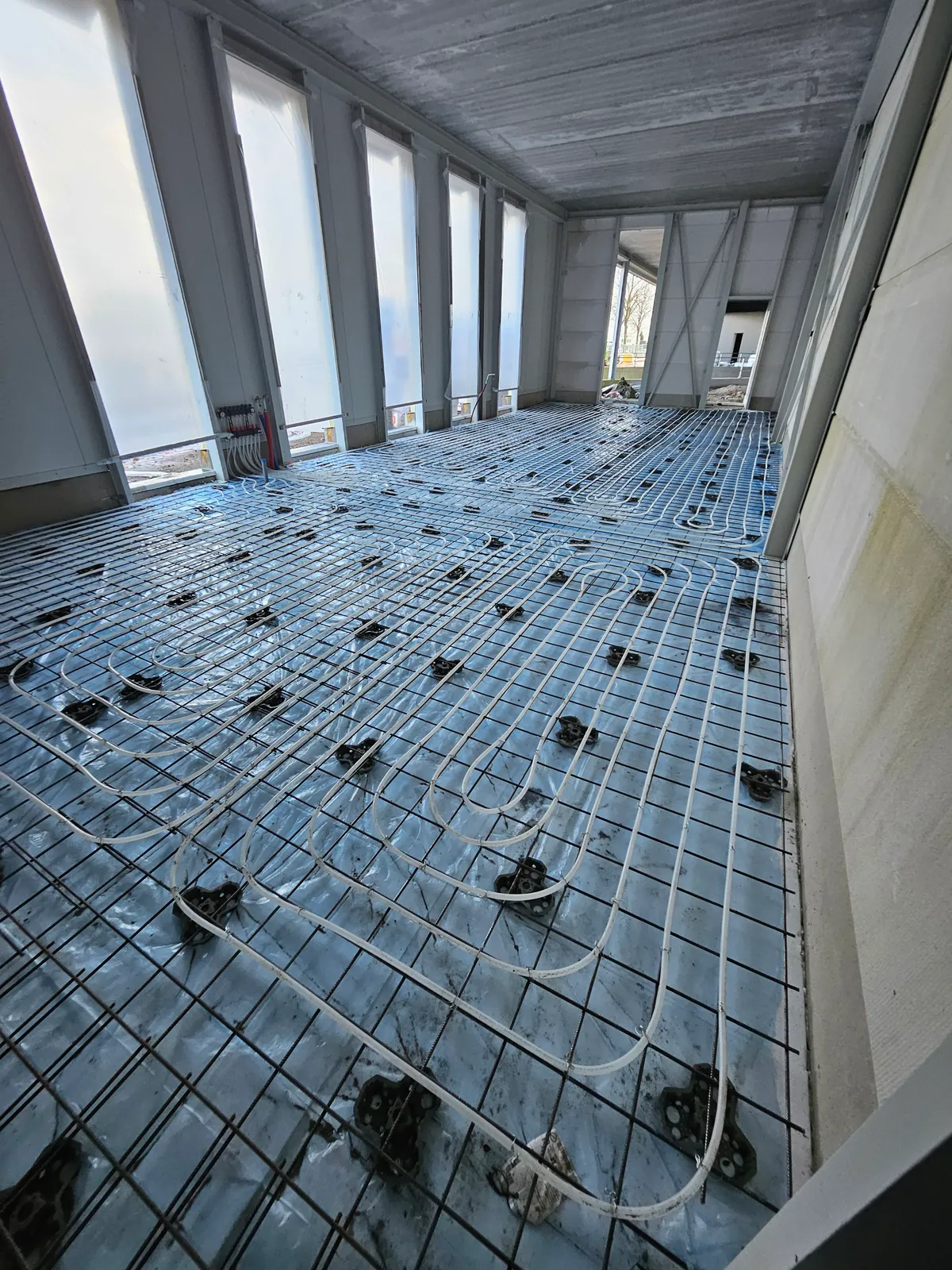 Overzicht van krimpnetten met vloerverwarmingsleidingen op reflecterende folie