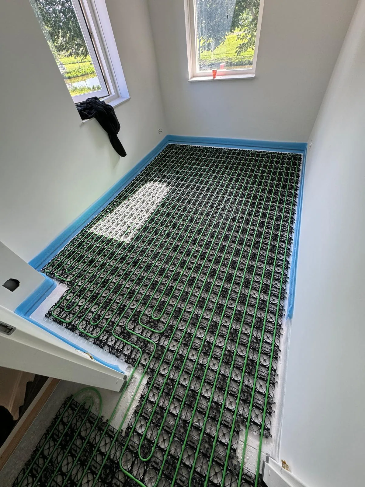 Warp Systems groen raster met vloerverwarmingsleidingen in kamer